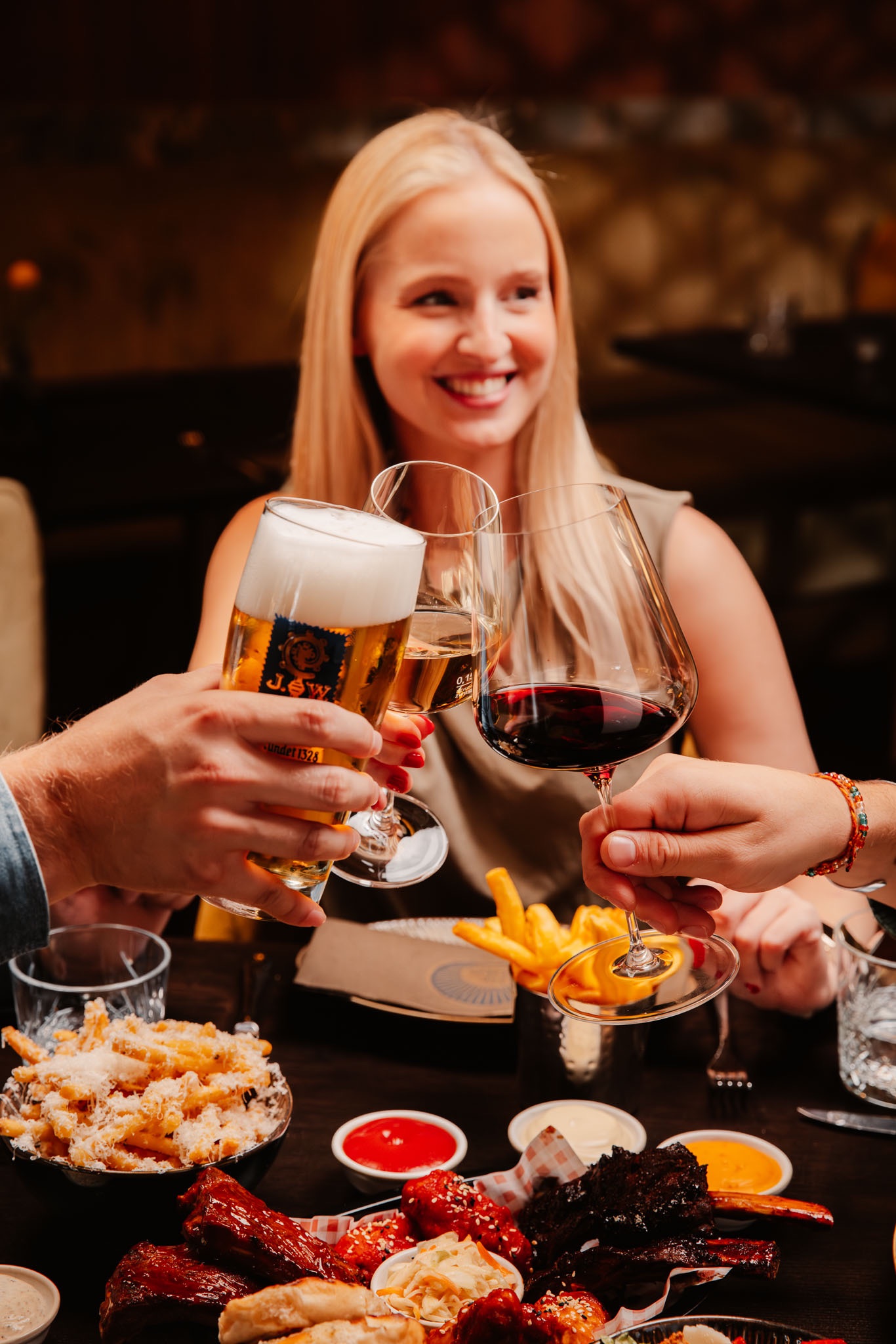 Feiernde Gäste stoßen im St.Ribs München an – Abschluss eines Firmenevents