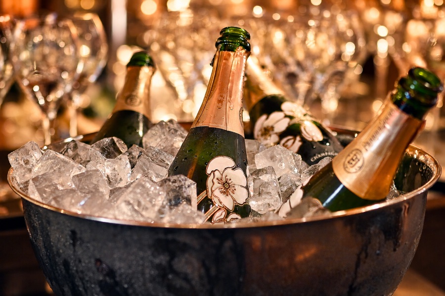 Champagnerflaschen auf Eis in einem Kühler vor funkelnden Gläsern im St.Ribs München