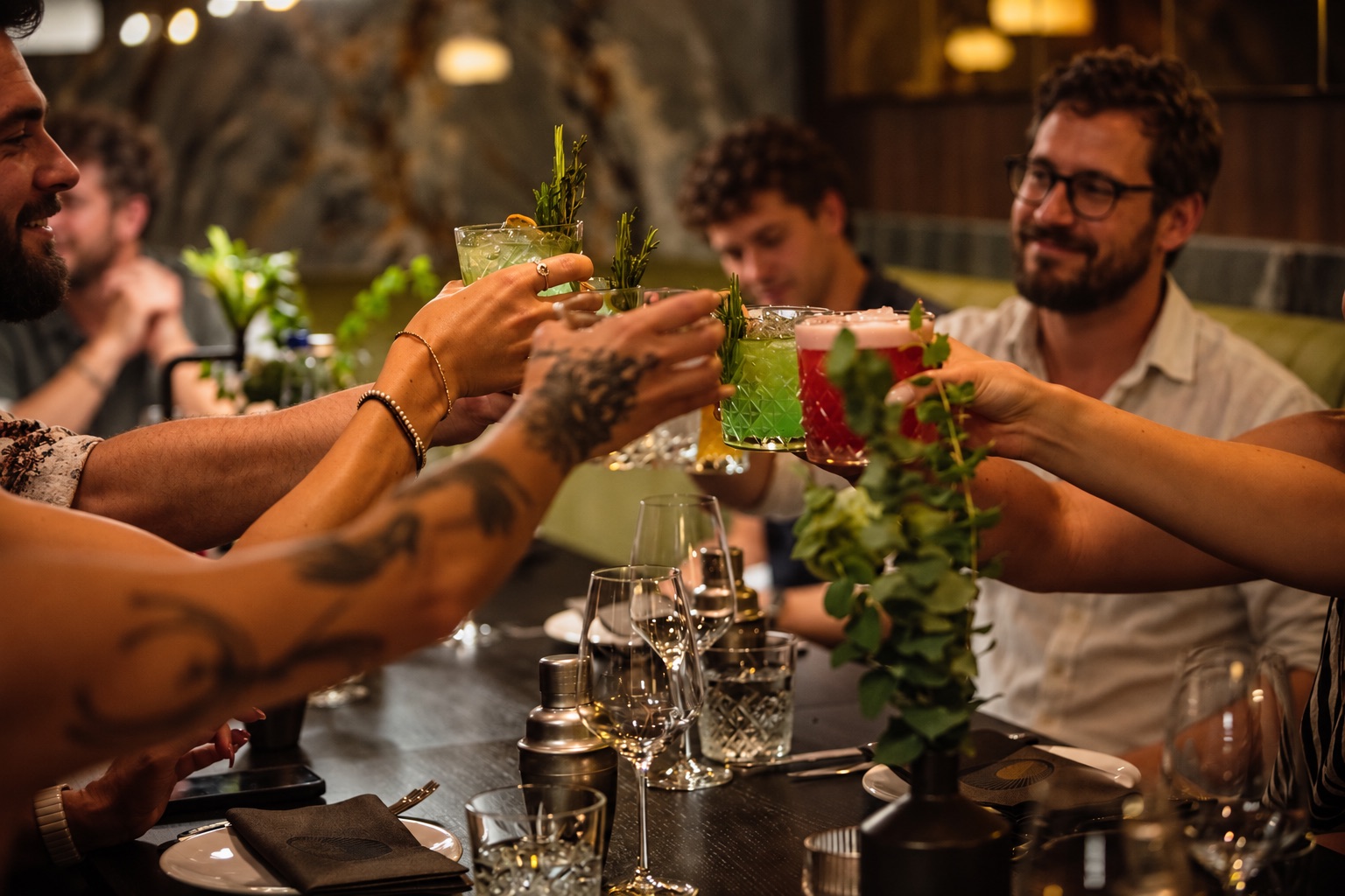 Team stößt mit Cocktails an der Tafel im St.Ribs München an