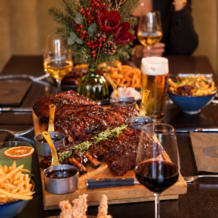 Weihnachtlich gedeckter Tisch mit Ribs-Board, Beilagen und Adventsgesteck im St.Ribs München